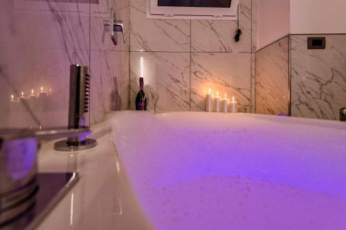 La salle de bains est pourvue d'une baignoire avec un éclairage violet. dans l'établissement Sara luxury apartament 2, à Sorrente