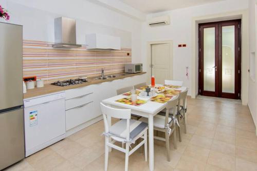 uma cozinha com uma mesa branca e cadeiras numa cozinha em Sara luxury apartament 2 em Sorrento