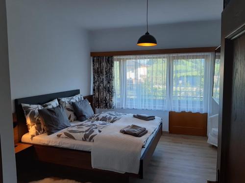 a bedroom with a bed and a large window at Exklusiv Apartment Sonnenalp in Niederau