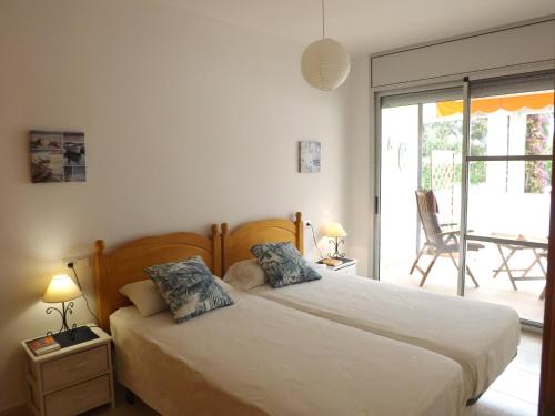 - une chambre avec 2 lits et une porte coulissante en verre dans l'établissement Encantadora casa en la playa, parque natural Delta del Ebro, à Amposta