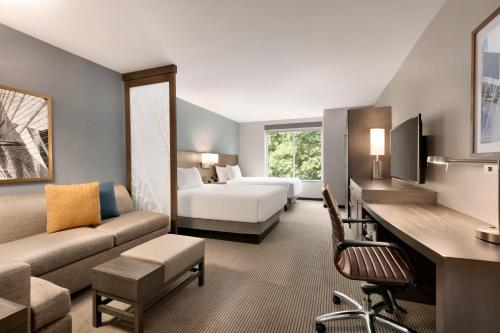 a hotel room with a bed and a living room at Hyatt Place Fort Lee/George Washington Bridge in Fort Lee