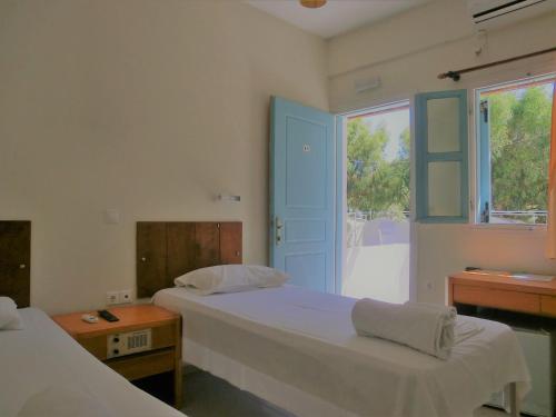 two beds in a room with a window and a bed sidx sidx sidx at Santorini Camping/Rooms in Fira