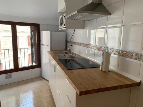 韋斯卡的住宿－Apartamento dúplex en el centro de Huesca，厨房配有白色橱柜和木制台面