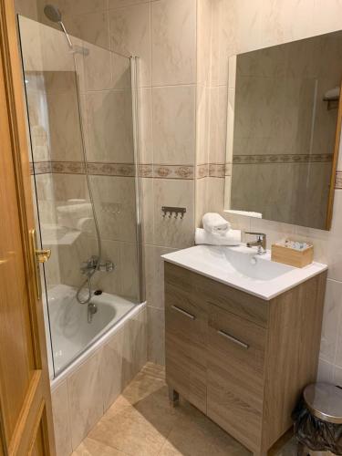 La salle de bains est pourvue d'un lavabo, d'une douche et d'une baignoire. dans l'établissement Apartamento dúplex en el centro de Huesca, à Huesca
