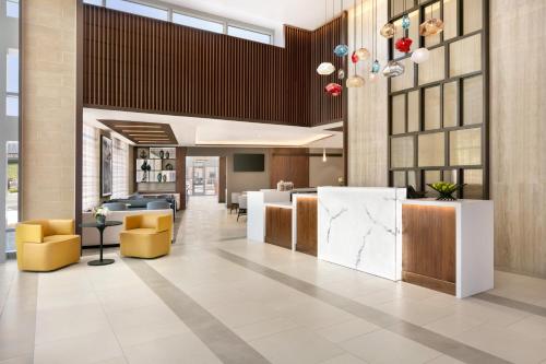 an office lobby with yellow chairs and a counter at Hyatt Place Fort Lee/George Washington Bridge in Fort Lee