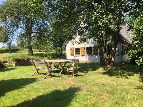 a picnic table and bench in front of a house at Klimatyczny Dom Kopaczówka przytulna miejscówka z kominkiem, sauną i ogrodem u podnóża Gór Stołowych in Wünschelburg