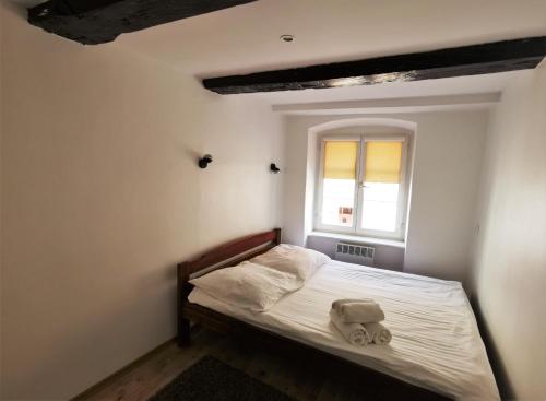 Dormitorio pequeño con cama y ventana en Apartament Pod Krzywą Wieżą - zameldowanie 24 h, en Toruń