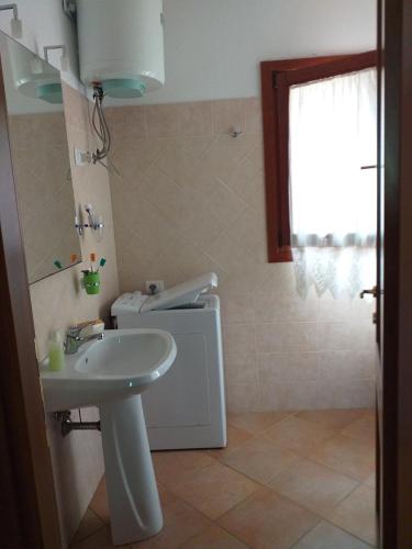 a bathroom with a sink and a toilet at Casa sorriso in San Teodoro