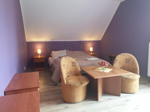 a room with a table and chairs and a bed at Gospodarstwo Agroturystyczne Damroka in Szymbark