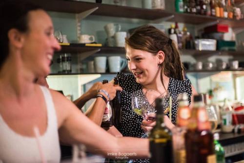 a woman standing at a bar with a bartender at Vakantiewoning in Mol centrum met eigen bar "CasaCuriosa" in Mol