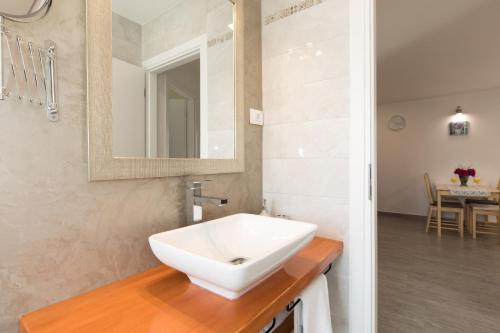 een badkamer met een witte wastafel en een spiegel bij Apartman Mares in Krk