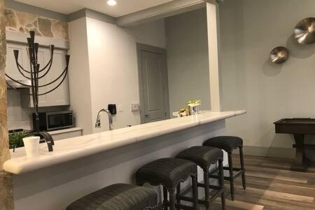 a bar with a row of stools and a mirror at Magnificent Furnished Apartment near Exxon Campus in Spring