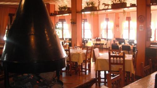 a restaurant with a large piano in a room with tables at Hotel Bellavista in La Puebla de Castro