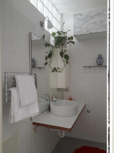 un bagno bianco con lavandino e specchio di Monolocale Liola a Mestre