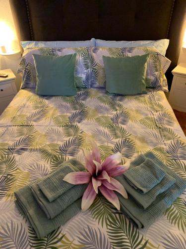 a bed with two pillows and a flower on it at Dream Ravine in Santa Cruz de Tenerife
