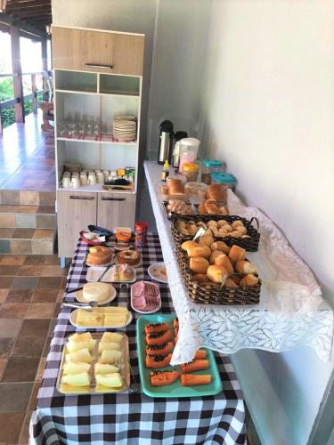 une table remplie de toutes sortes de pâtisseries dans l'établissement Pousada Recanto do Lago, à Capitólio