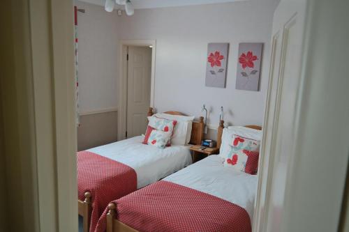 2 posti letto in una camera con rosso e bianco di Weston Cottage a Poole