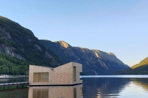 a brick house on a body of water with mountains at Dalen Studio 1 in Dalen