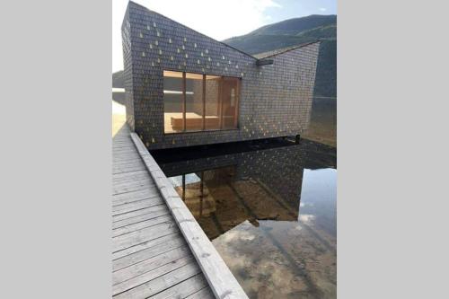 a house on top of a body of water at Dalen Studio 1 in Dalen
