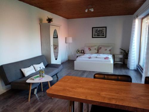 - un salon avec un lit et une table dans l'établissement Schöne EinZimmer Wohnung Zwischen Bodensee und Allgäu, à Neukirch