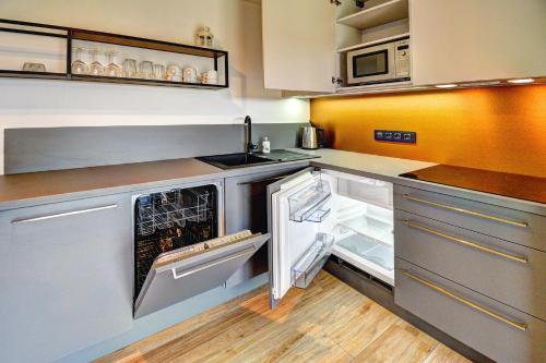 an empty kitchen with an open refrigerator and microwave at Dvě Zátoky Kovářov in Kovářov
