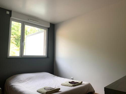 een slaapkamer met een bed met twee handdoeken erop bij Appartement des trois frontières in Apach