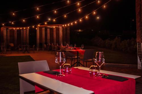 a group of tables with wine glasses and lights at Orizzonte MHotel in Andria