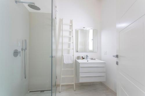 Baño blanco con lavabo y escalera en Affittacamere Ortygia Inn Rooms con Terrazza sul Mare e Jacuzzi en Siracusa