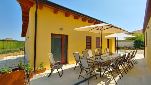 a patio with a table and chairs and umbrellas at la Casa del Vino - B&B in Tollo