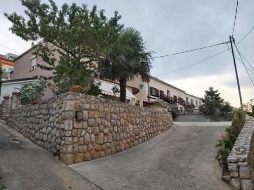 a stone wall in front of a house at Apartmani Afrodita in Crikvenica