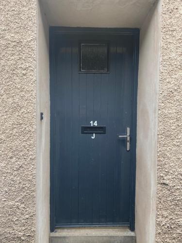 Una puerta azul con el número. en Cosy studio flat, en Montrose