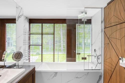 a bathroom with a tub and a sink at Nosalowy Park Hotel & Spa in Zakopane