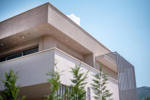 a building with trees in front of it at SunBlue Boutique Villas in Skala Rachoniou