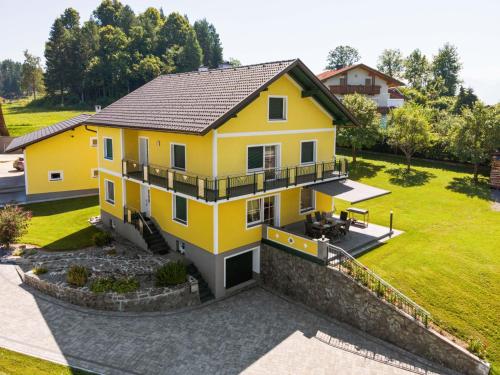 żółty dom z czarnym dachem w obiekcie Holiday home in Carinthia near Lake Woerthersee w mieście Köttmannsdorf