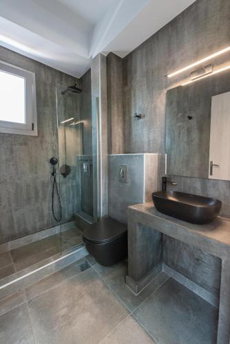 a bathroom with a sink and a toilet and a shower at SunBlue Boutique Villas in Skala Rachoniou