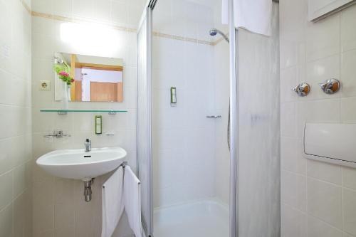 a bathroom with a shower, sink, and toilet at Tannmühle Hotel und Restaurant GmbH in Callenberg