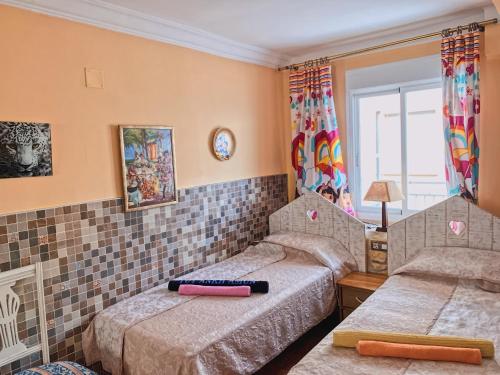 a bedroom with two beds and a window at Preciosos Apartamentos Caracola EN LA PRIMERA LINEA DE LA PLAYA DE GANDIA in Gandía