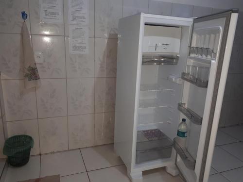 an empty refrigerator with its door open in a kitchen at Casa para temporada in Belém