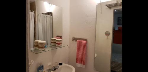 a bathroom with a sink and a toilet and a mirror at You & Me Tropical Studio in San Juan