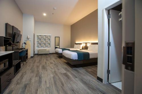 a hotel room with a bed and a bathroom at Studio 6 North Platte - East in North Platte