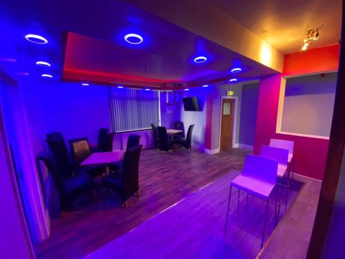 a room with purple lights and tables and chairs at Glorious catering & Restaurant BnB in Ocker Hill