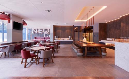 un restaurante con mesas y sillas y un bar en Holiday Inn Express Newcastle, an IHG Hotel en Newcastle