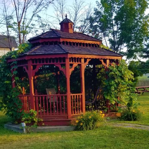 a wooden gazebo in the middle of a yard at Lake Erie Lodge in Erie