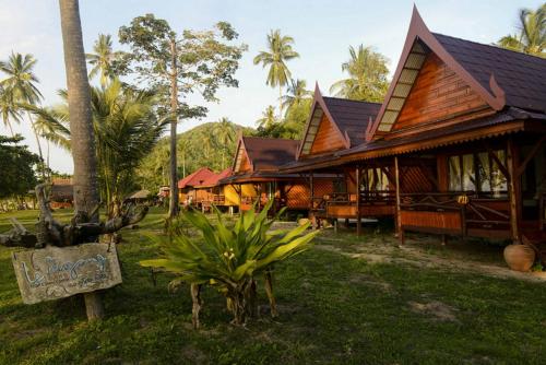 une maison avec un panneau devant elle dans l'établissement Le Dugong Libong Resort, à Ko Libong