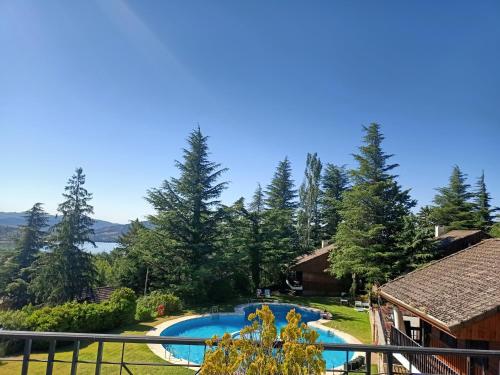 uitzicht op een zwembad naast een huis bij Cabañas Navacerrada in Navacerrada