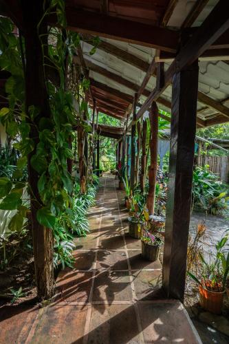 a covered walkway in a garden with potted plants at Princesa de la Luna Ecolodge in Fortuna