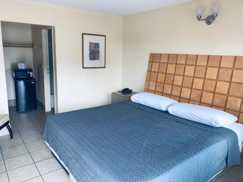 a bedroom with a bed with a blue comforter at Hotel Galaxy in Las Vegas