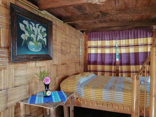 a small bedroom with a bed and a table at Cabañas Los Achicuales in Cuetzalán del Progreso