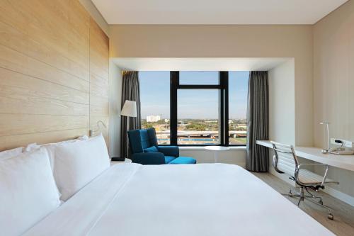 a hotel room with a large bed and a desk at Haikou Meilan International Airport Hotel in Haikou