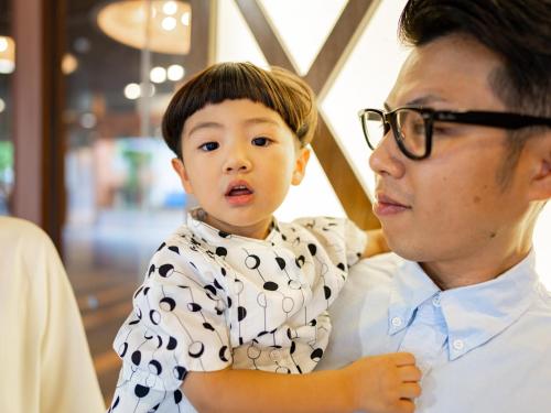 a man holding a young boy on his shoulders at Hotel Flags Isahaya Nagasaki in Isahaya